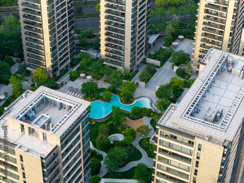 Aerial view of modern residential area featuring greenery, water features, and recreational spaces in urban setting.