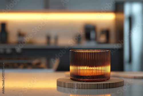 Amber candleholder on a wooden coaster in a kitchen.