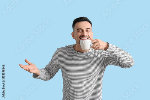 Happy young man with cup of...