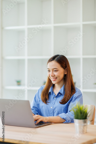 Young attractive business asian woman working on her project with laptop computer in modern workplace office room.
