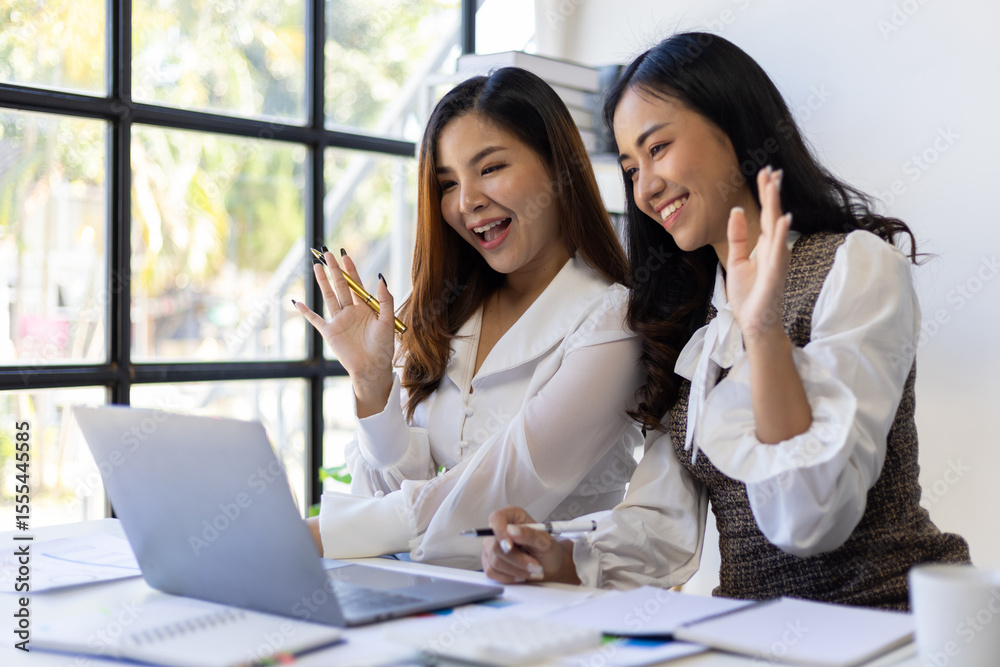 Obraz premium Employees and female co-workers are excited and happy about their promotions and bonuses while looking at their laptop.