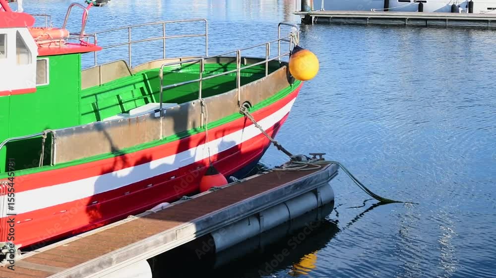 barco pequeño de color rojo y verde aparcado en un puerto