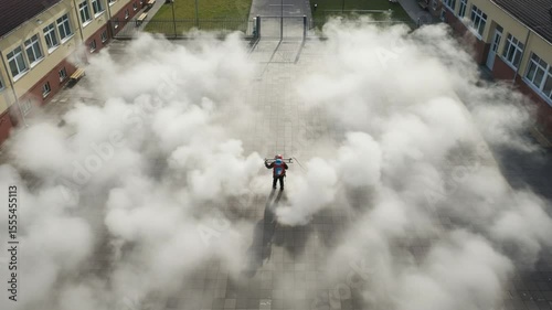 Worker Disinfecting Outdoor Area with Sprayer Drone Aerial Shot