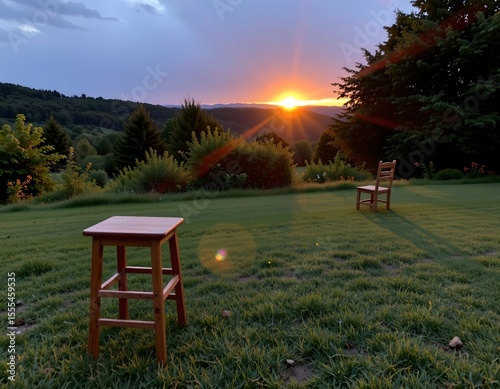 the image features a tranquil outdoor scene during what appears to be either sunrise or sunset, given the warm glow on the horizon and the elongated shadow of the bar stool