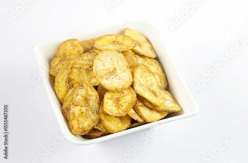 Indian homemade crispy snacks called banana chips serve in bowl isolated on white background 