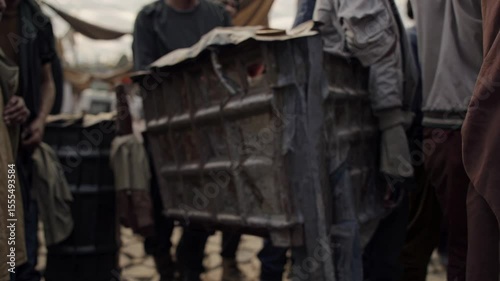 Desperate refugees transporting meager possessions, women and children moving through crowded temporary shelter, portraying human resilience amid humanitarian crisis