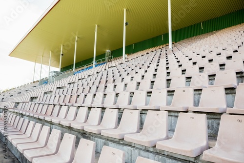 Flat design is featuring rows of empty beige plastic seats under yellow canopy with green columns