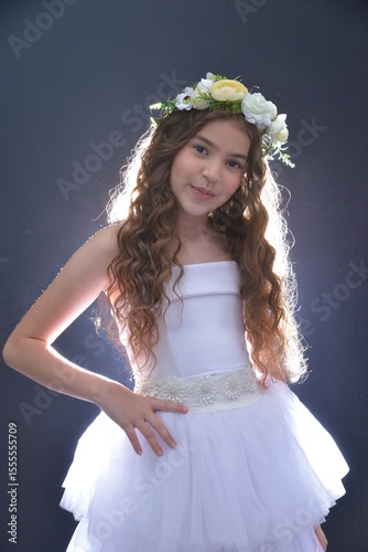 High resolution close up studio portrait of a single beautiful 12 year old Caucasian girl in a fancy white dress and a beautiful flower crown on her head