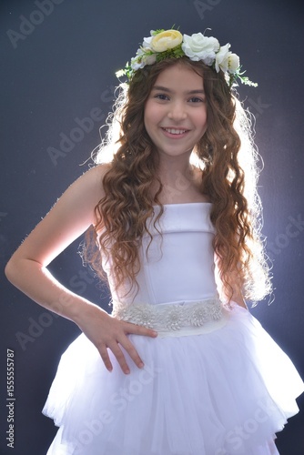 High resolution close up studio portrait of a single beautiful 12 year old Caucasian girl in a fancy white dress and a beautiful flower crown on her head