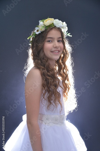 High resolution close up studio portrait of a single beautiful 12 year old Caucasian girl in a fancy white dress and a beautiful flower crown on her head