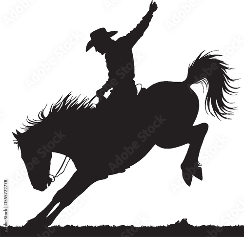 Silhouette of a cowboy riding a bucking bronc horse with gesture of triumph.