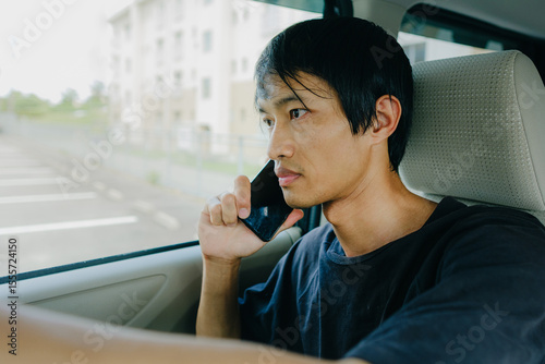 Young Asian Man Talking on Smartphone Inside Car – Urban Lifestyle Concept