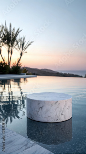 White marble cylinder beside tranquil water reflection podium