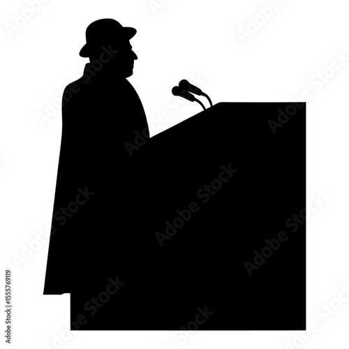 Silhouette of a man in a hat speaking at a podium with two microphones visible here