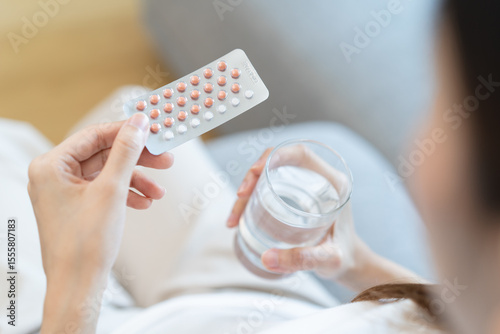 young female holding birth control pills photo