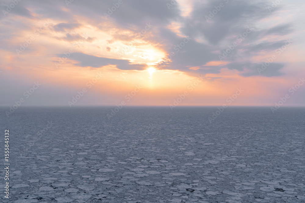 Fototapeta premium 知床のプユニ岬から眺めるオホーツク海の流氷と夕日