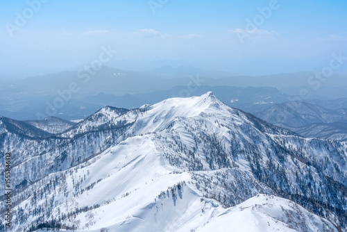 山頂から冬の雪山を眺める