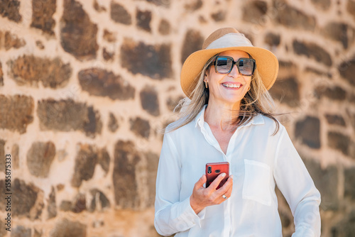 middle-aged adult woman on the street with a mobile phone or smartphone