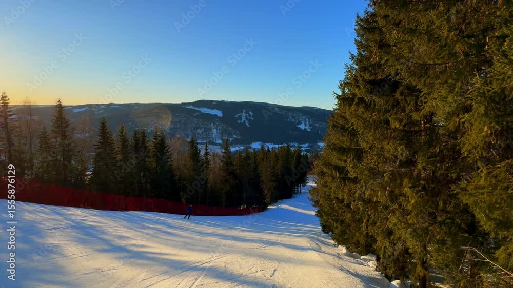 Telemark downhill skier skiing Hafjell Alpine ski resort Øyer mountain Norway Norge arctic sunset golden hour steep down run Olympic torch man Lillehammer clear skies groomed trail runs icy follow