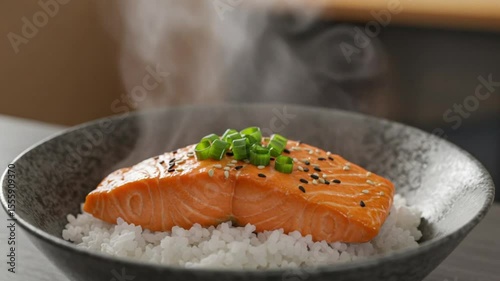 Steaming Salmon Delight: A culinary masterpiece of perfectly cooked salmon, gleaming atop a bed of fluffy white rice, is garnished with fresh green onions. Capturing the essence of flavor and aroma.