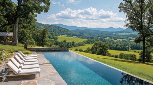 A view of the hills from an infinity pool with la white lounge chairs, overlooking distant mountains