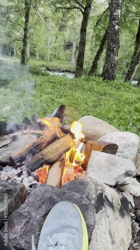 View of the fireplace, mountains, and lake.  Flames. Barbecue stones. Warming up by the fire. Mountain romance.
