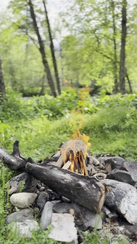 View of the fireplace, mountains, and lake.  Flames. Barbecue stones. Warming up by the fire. Mountain romance.