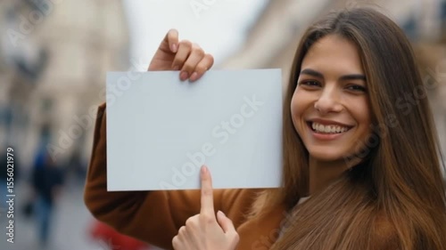 Woman background street holding a sign , smiling and pointing at the sign
