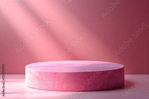 Pink cylindrical podium with textured surface against a pink bac
