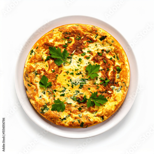 a cooked egg dish rests on a round plate, isolated against a solid background. the food item is circular, golden brown, and speckled with green herbs
