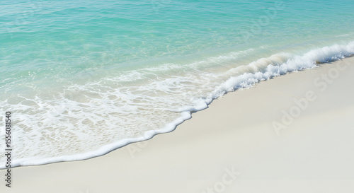 Close-up of clear turquoise sea water gently washing over clean white sand. Soft textures and minimalist beach vibe ideal for backgrounds and summer content.