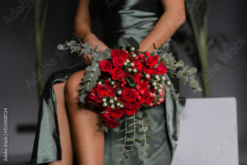 Bild auf Leinwand beautiful mulatto woman with a large bouquet of scarlet roses