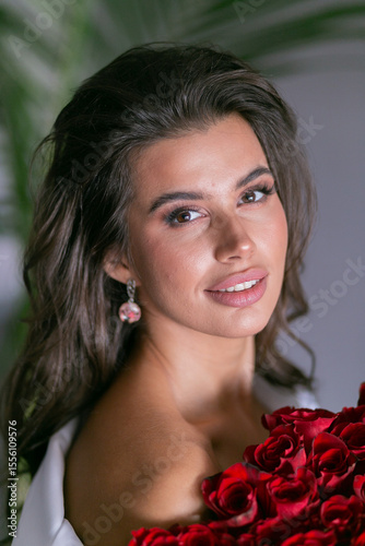 Foto beautiful mulatto woman with a large bouquet of scarlet roses
