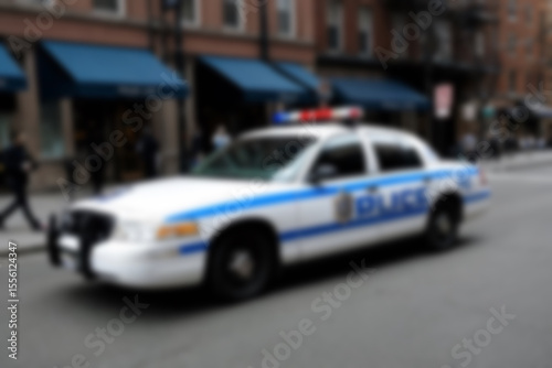 Blurry photo of a police car patrolling the busy city center.