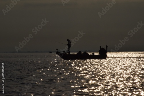 Angler fishing at sunrise in a boat