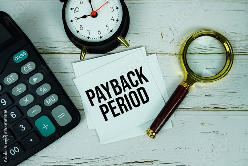 Slika na platnu Payback Period text message on paper with magnifying glass, calculator and alarm