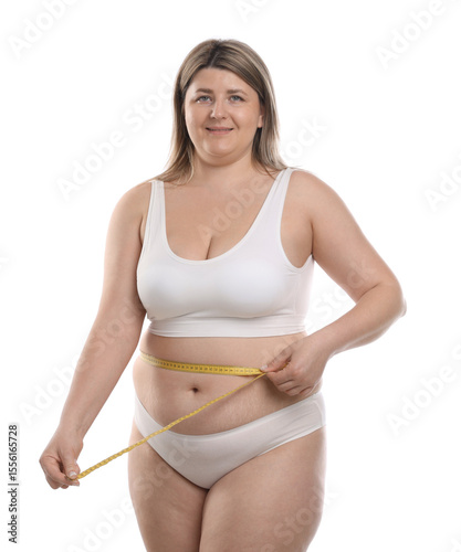 Weight loss. Plus size woman measuring waist with tape on white background