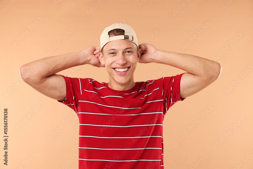 Naklejka premium Young man in stylish baseball hat on beige background