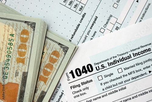 Hundred dollar bills and 1040 individual income tax return form blank close up photo