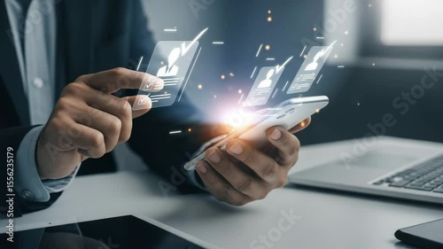 Person holding phone with digital profiles and checkmarks in a business setting at a desk