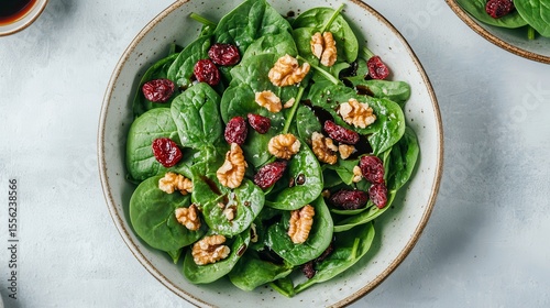 Healthy Greens: A vibrant salad, boasting fresh spinach, rich cranberries and walnuts, an appetizing culinary experience