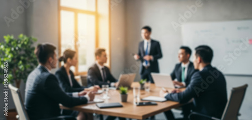 A group of business people are meeting in a bright conference room.