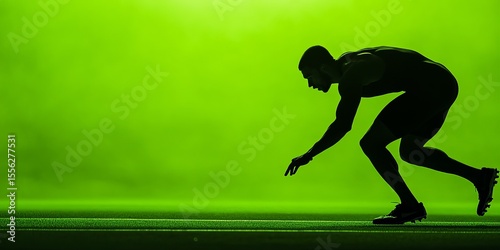 The intense focus of a sprinter at the starting line under a vibrant green light signals the start of a track and field competition.