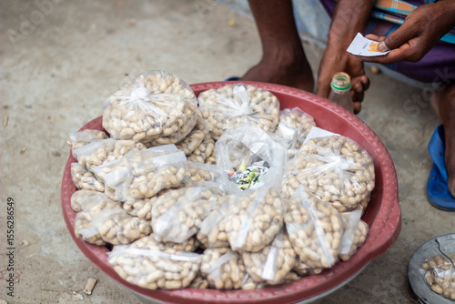 A young man is holding a nut, and the background behind it is blurred.