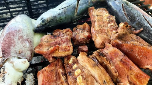 grilled fish and cuttlefish and rib meat on the grill over coals