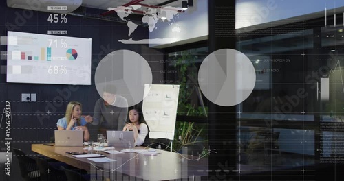 Presenter picking remote and advancing animated charts while colleagues reviewing business metrics