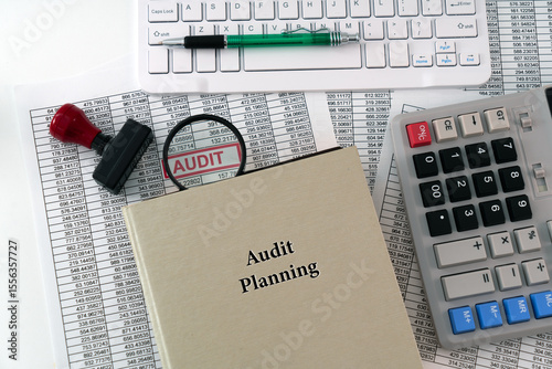A photo illustration for Audit Planning; A detailed report is placed under a magnifying glass, symbolizing scrutiny, with a book of audit planning displayed in the foreground