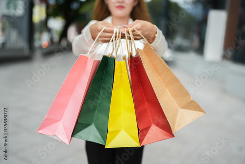 Joy of Shopping: A woman holds aloft a spectrum of vibrant shopping bags, encapsulating the essence of retail therapy.