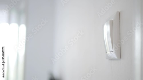 Opening the Light from the Switch in the Office. One Person Turning on the Light in a Room. Saving Electricity, Economy Concept.