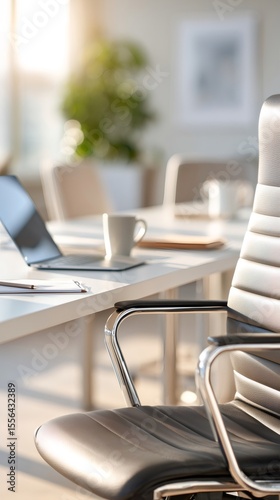 Comfortable office chair sitting next to a desk with laptop and coffee cup